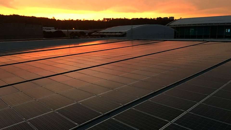 Photovoltaik-Kraftwerk: eine Aufdachanlage auf den Philippinen im Sonnenaufgang.