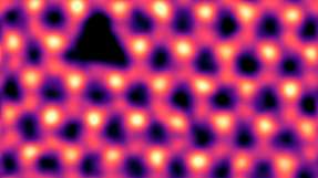 Einzelne Stickstoff-Leerstellen (dreieckiger dunkler Kontrast oben links), die durch Elektronenbestrahlung in hexagonalem Bornitrid erzeugt wurden. Gefiltertes und gefärbtes rastertransmissionselektronenmikroskopischen Bild.