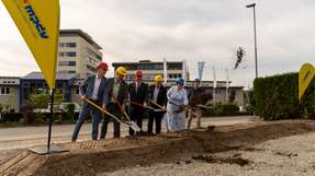 Gemeinsamer symbolischer erster Spatenstich. Im Hintergrund sind die Firmengebäude der MPDV am Römerring 1 in Mosbach-Diedesheim zu sehen.