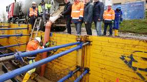  Flüssigboden für die Forschungsleitung: (rechts neben dem Betonmischer v.l.) Constantin Alsheimer, Vorstandschef Mainova, Walter Herlitschke, Geschäftsführer SWR Südwestdeutsche Rohleitungsbau, Werner Lutsch, Geschäftsführer Arbeitsgemeinschaft Fernwärme und Professor Thomas Neidhart, OTH Regensburg.