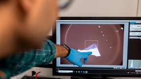 Dr. Nihit Saigal (Erstautor der Studie) wählt aus einer Kristallprobe bei mikroskopischer Betrachtung eine ultradünne Schicht zur weiteren Bearbeitung aus.
