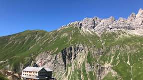 Auf 1.844 Metern Höhe thront die Kemptner Hütte bei Oberstdorf. Als eine der größten Hütten des Deutschen Alpenvereins (DAV) in den Allgäuer Alpen bietet sie Fernwanderinnen und Fernwanderern sowie Bergbegeisterten umgeben von majestätischen Gipfeln einen Rast- und Rückzugsort.