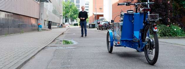 Dr. Tom Assmann ruft das autonome Lastenrad zu sich.